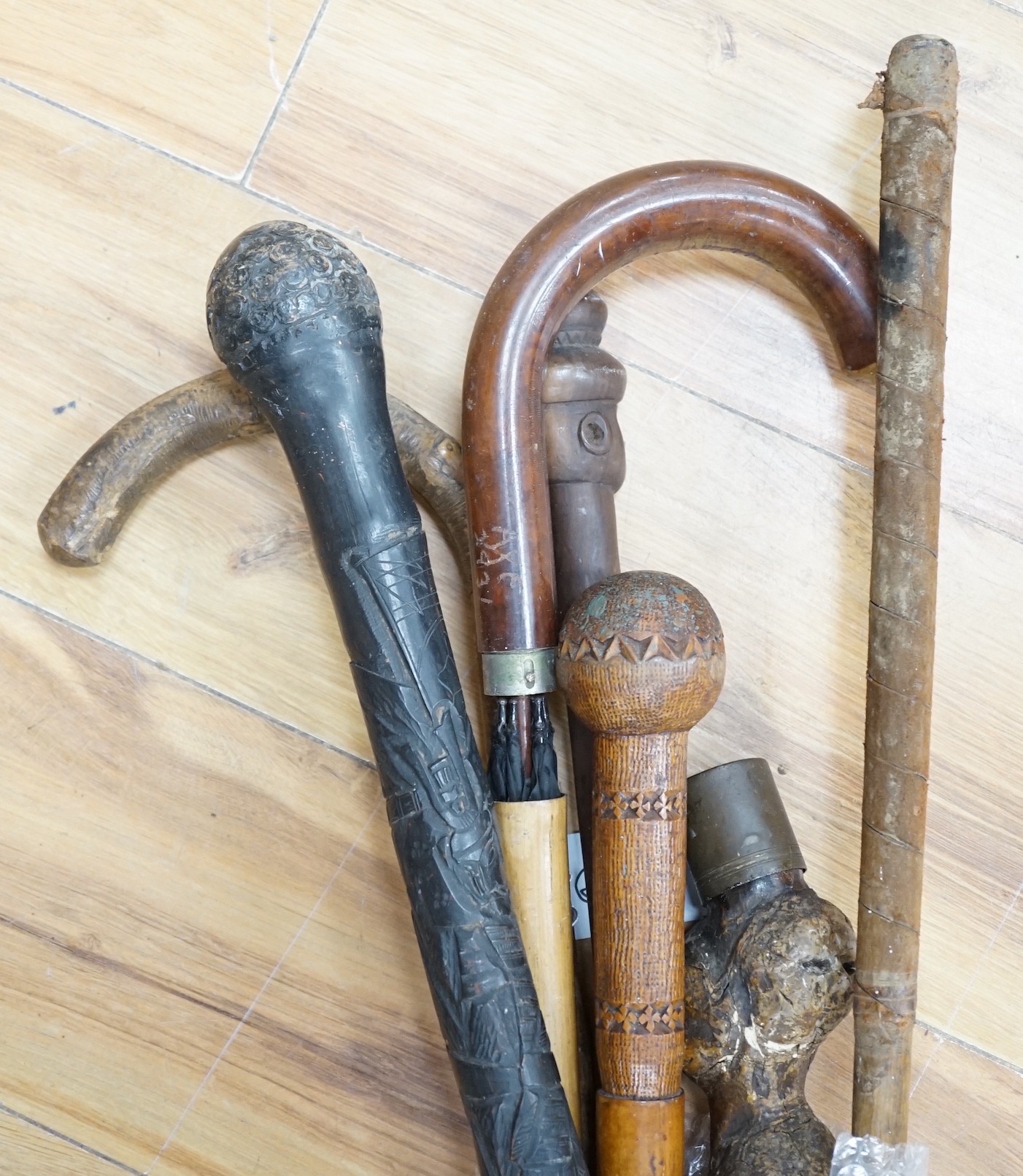 An early 20th century umbrella walking stick, five others and a golf club